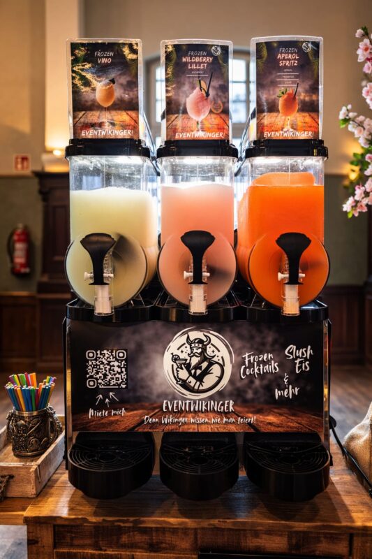 Frozen-Drink-Maschine mit drei Kammern: links Frozen Vino, in der Mitte Frozen Wildberry Lillet, rechts Frozen Aperol Spritz, jeweils mit Sortenschild